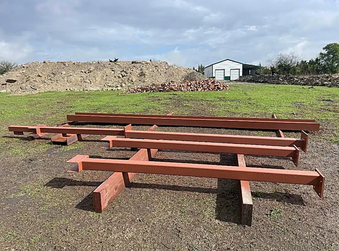 Prepped steel beams stacked for dugout construction